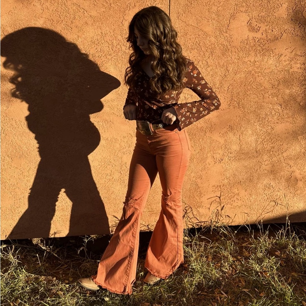 Mid-rise deep orange flare jeans with ripped knees
